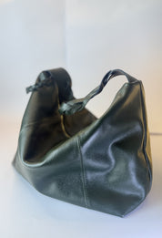 Bolso Trenza en cuero verde oscuro, vista lateral con la manija trenzada