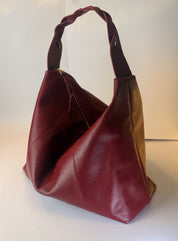 Bolso Trenza en cuero vino tinto, vista en tres cuartos con la manija trenzada